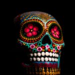 A vibrant and colorful sugar skull depicting Day of the Dead art with intricate designs on black background.