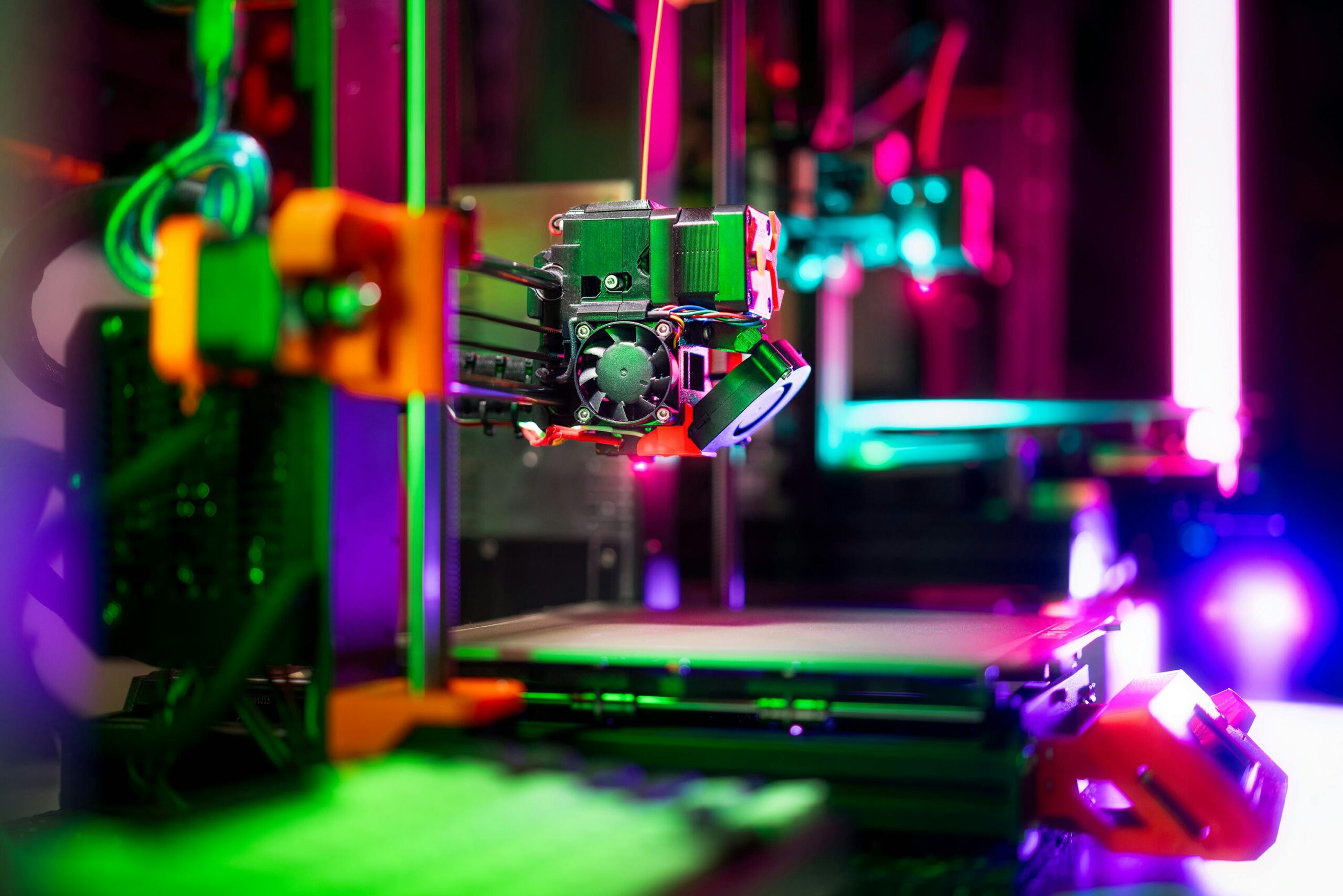 Close-up of a neon-colored 3D printer in a workshop, showcasing vibrant technology.